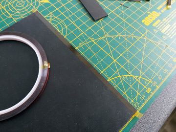 Photo of a rubber sheet with Kapton tape on it on a cutting mat